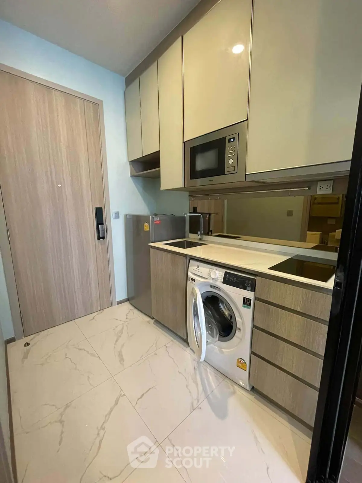 Modern kitchen with sleek cabinetry, built-in appliances, and marble flooring in a compact layout.