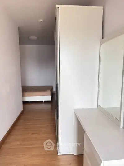Compact bedroom with minimalist furniture and wooden flooring