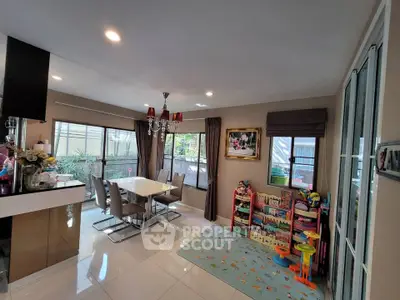 Spacious dining area with elegant chandelier and play corner, perfect for family gatherings.