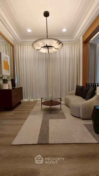 Elegant living room with modern chandelier, cozy sofa, and stylish decor, perfect for contemporary living.