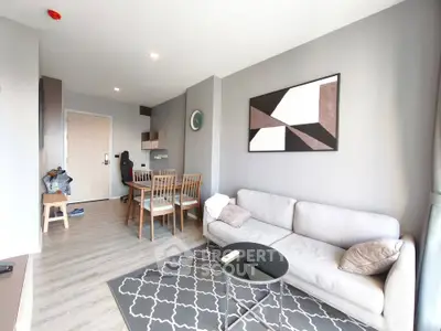 Modern living room with stylish decor and dining area in open layout apartment.