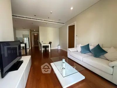 Spacious modern living room with elegant decor and open layout, featuring hardwood floors and stylish furniture.