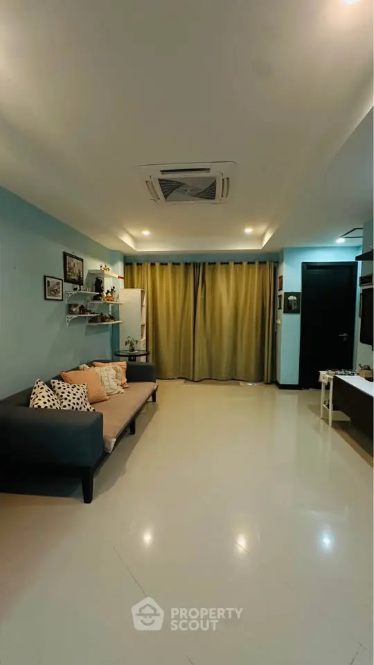 Spacious living room with modern decor and cozy seating area, perfect for relaxation and entertainment.