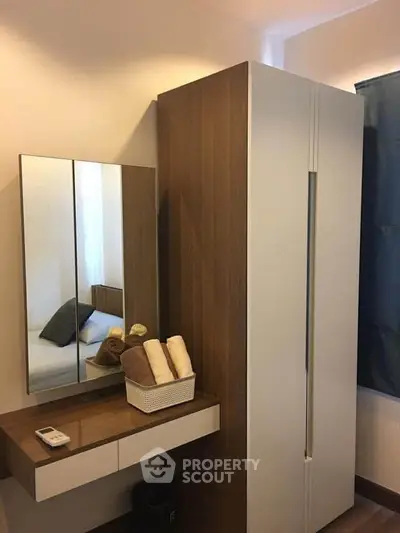 Modern bedroom with sleek wardrobe and mirror, showcasing minimalist design.
