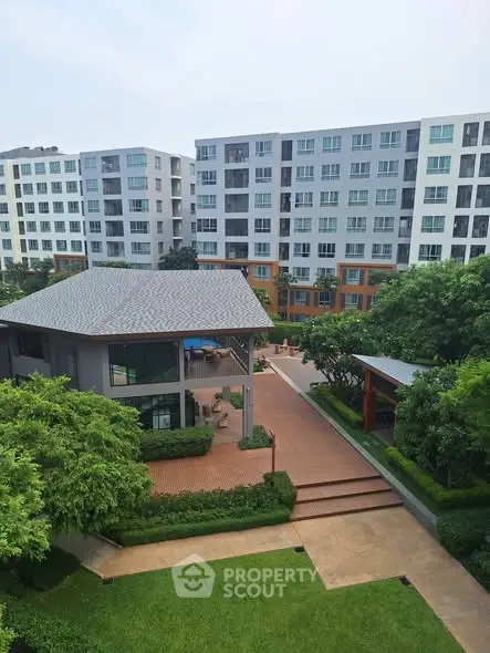 Modern apartment complex with lush greenery and spacious outdoor areas.