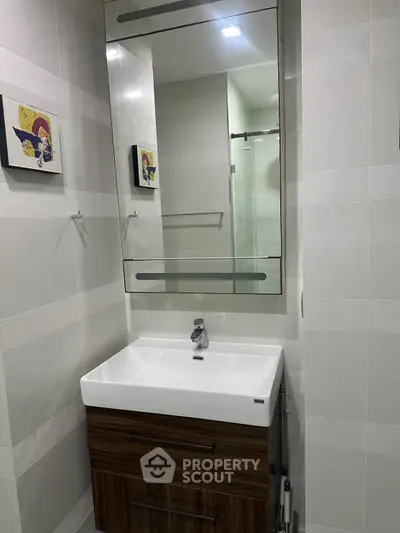 Modern bathroom with sleek vanity and mirror in contemporary apartment.