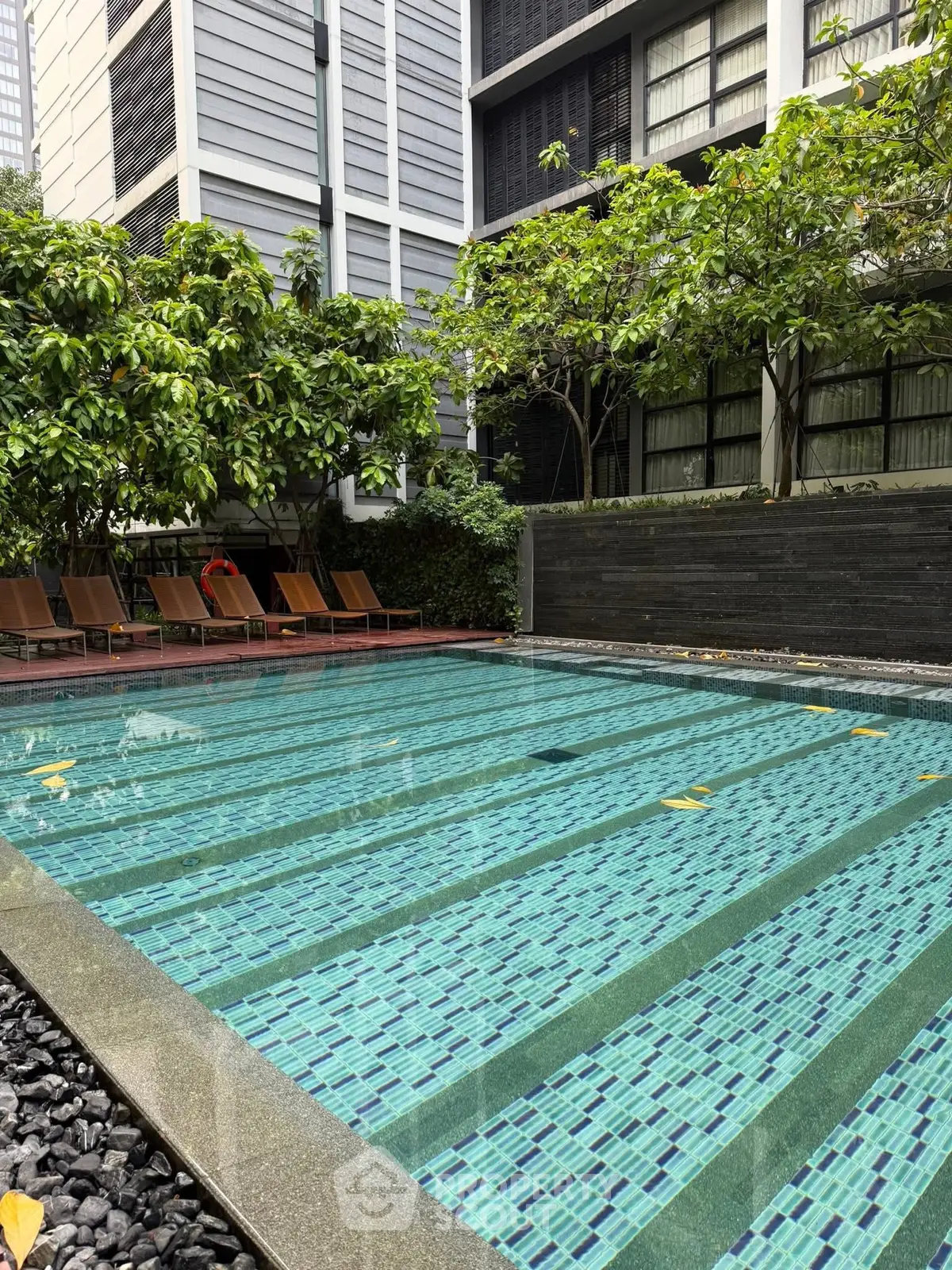 Luxurious residential pool area with modern design and lush greenery, perfect for relaxation and leisure.