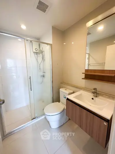 Modern bathroom with glass shower and sleek fixtures in a contemporary apartment.