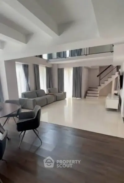 Spacious modern living room with high ceilings and elegant staircase