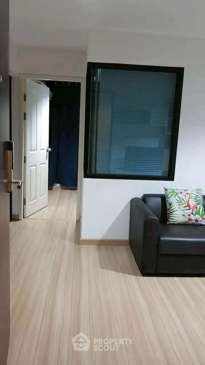 Modern apartment interior with sleek wooden flooring and cozy seating area.