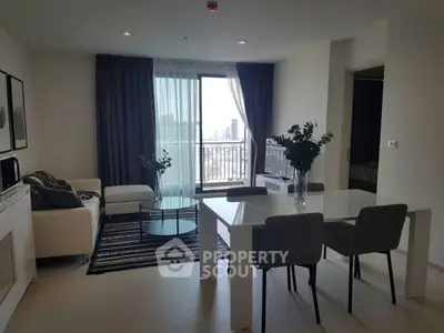 Modern living room with dining area and balcony view in a stylish apartment.