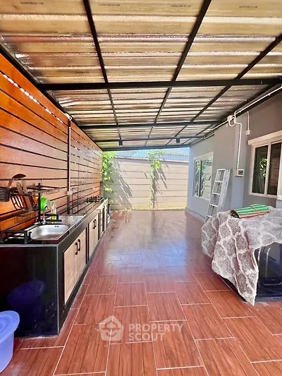 Spacious covered outdoor kitchen with modern amenities and stylish wooden accents.