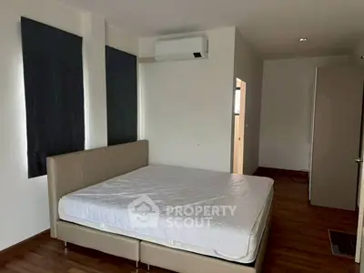 Spacious bedroom with modern air conditioning and wooden flooring, perfect for comfort and relaxation.