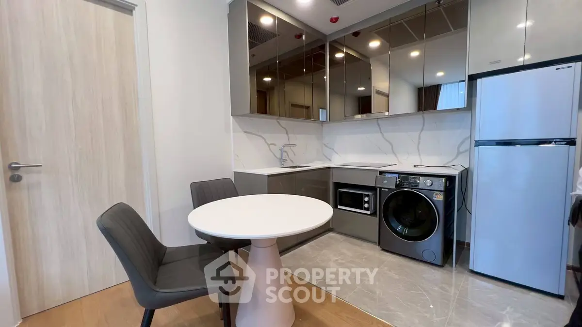 Modern kitchen with sleek appliances and dining area in stylish apartment