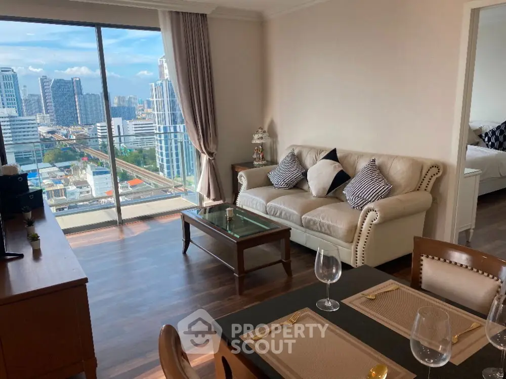 Spacious living room with city view, elegant furniture, and dining area in modern apartment.