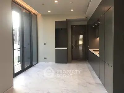 Modern kitchen with sleek cabinetry and marble flooring in a luxury apartment.