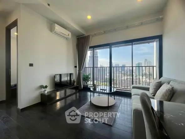Modern living room with city view, featuring sleek furniture and large windows for natural light.
