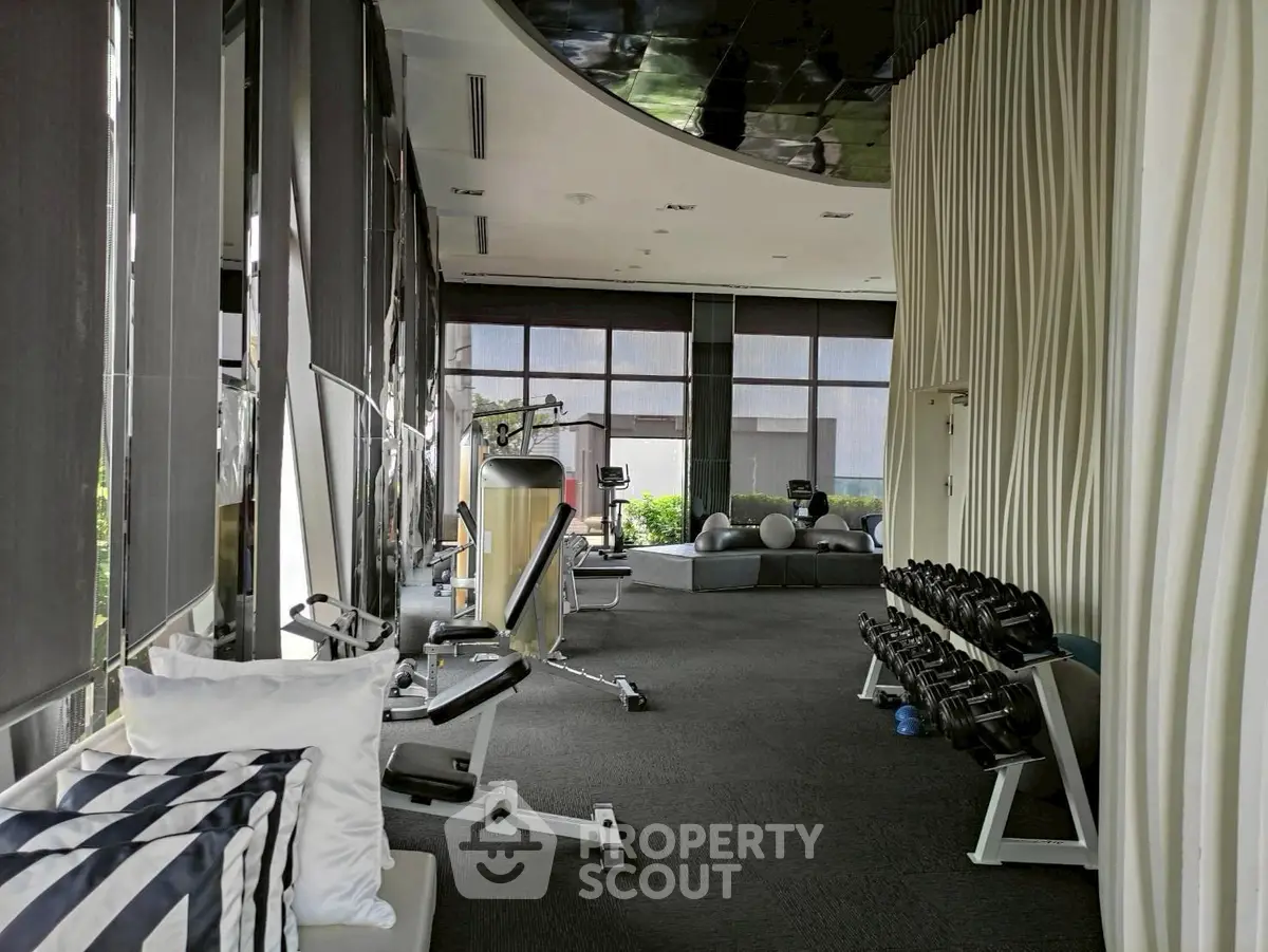 Luxurious gym with modern equipment and stylish decor in a high-end residential complex.