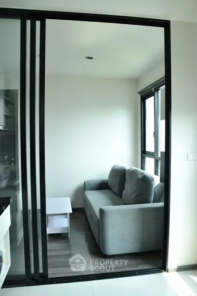 Cozy modern living room with sliding glass doors and plush gray sofa.