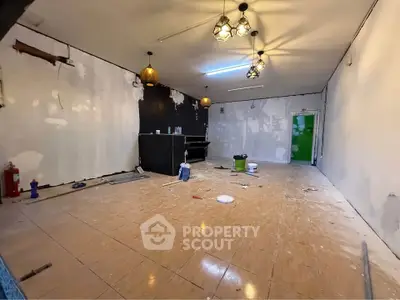Spacious interior under renovation with modern lighting and tiled flooring
