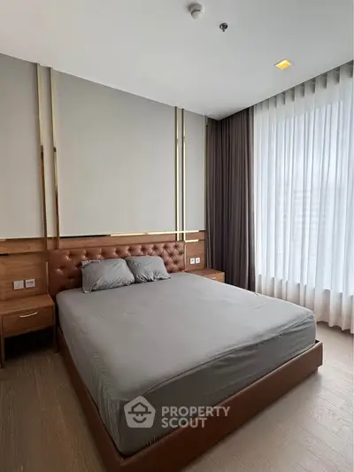 Modern bedroom with elegant decor and large window for natural light.