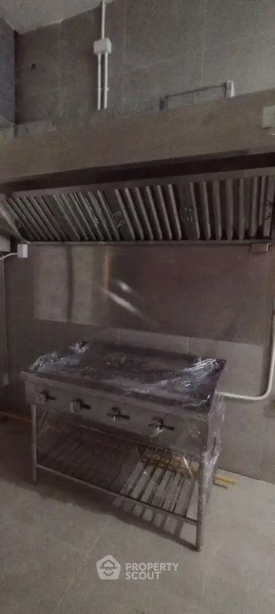 Commercial kitchen with industrial stove and ventilation system