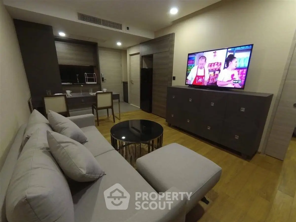 Modern living room with sleek furniture and large TV, perfect for relaxation.