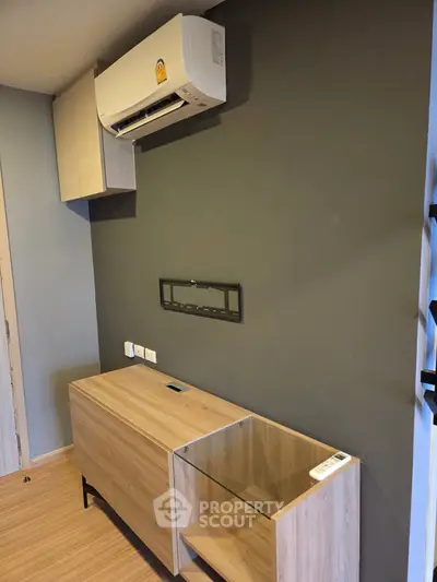 Modern living room with wall-mounted air conditioner and sleek wooden furniture