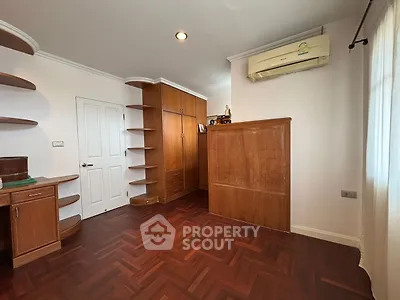 Spacious room with wooden flooring and built-in shelves, perfect for a home office or study.
