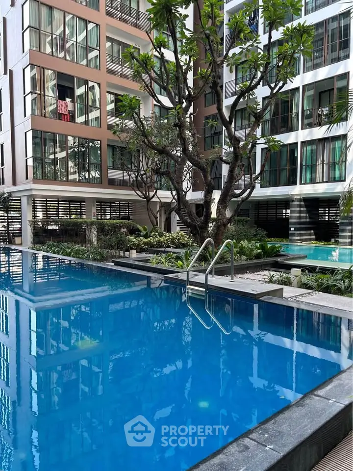 Luxurious condominium with stunning pool and lush greenery in a modern setting.