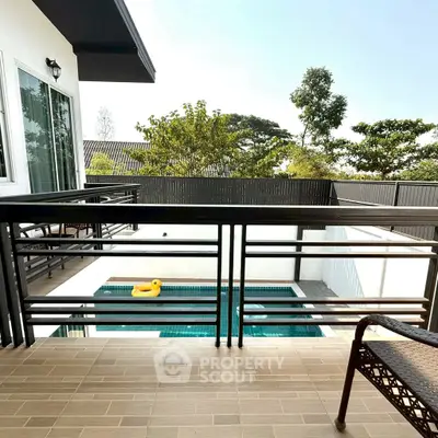 Modern balcony overlooking a private pool with lush greenery