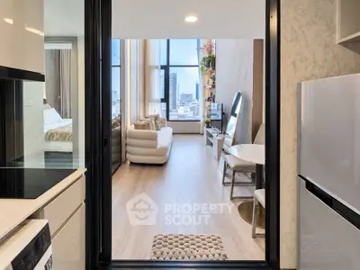 Modern apartment interior with open kitchen and stylish living room, featuring large windows and elegant decor.