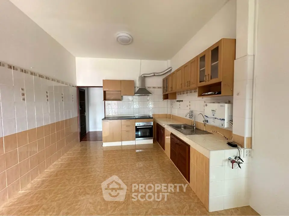 Spacious kitchen with modern cabinetry and tiled flooring in a bright open layout.
