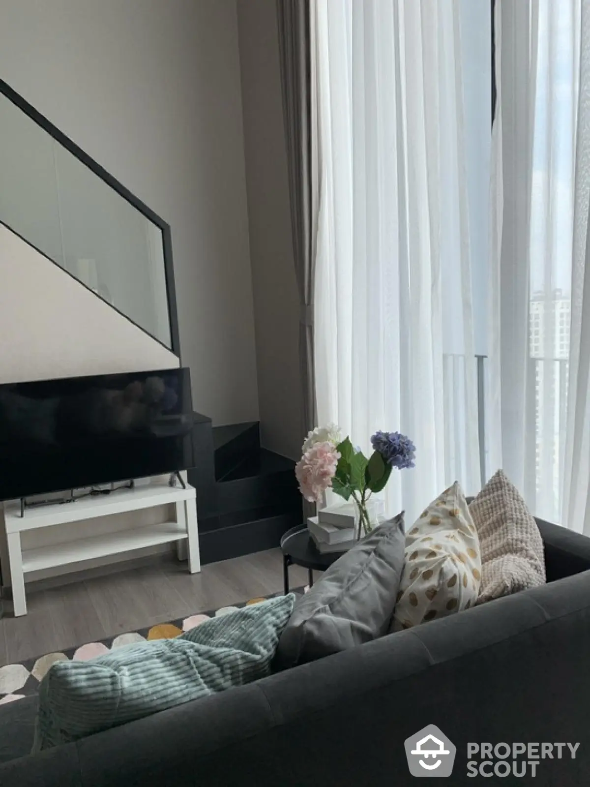 Modern living room with high ceiling and large windows