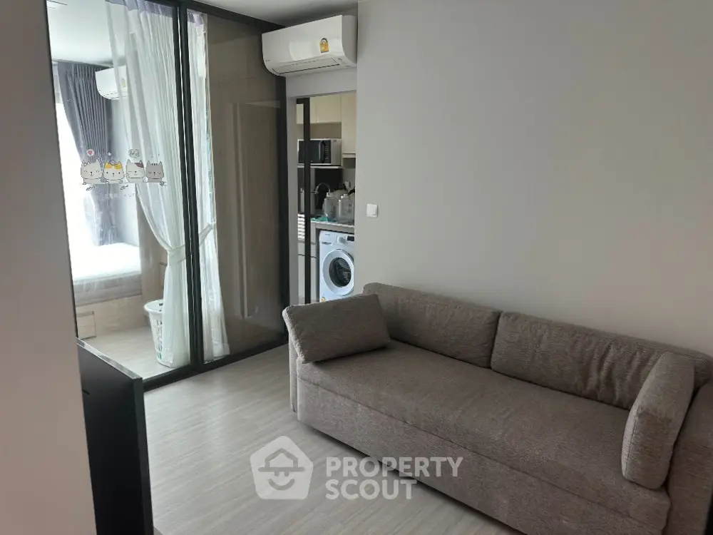 Modern apartment interior with cozy living room and view into bedroom and kitchen