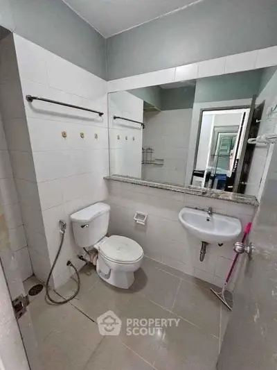 Modern bathroom with sleek fixtures and large mirror, perfect for a contemporary home.