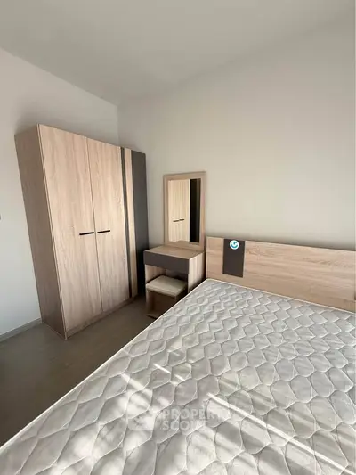 Modern bedroom with wooden wardrobe and stylish bed frame, perfect for cozy living.