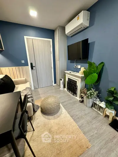 Cozy living room with modern decor, featuring a wall-mounted TV and air conditioning.