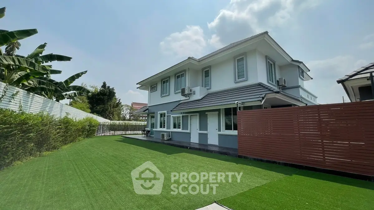 Spacious modern two-story house with lush green lawn and privacy fence