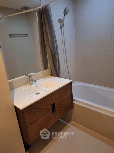 Modern bathroom with sleek vanity and bathtub in contemporary apartment.