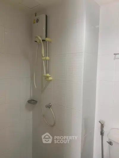 Modern bathroom with sleek white tiles and shower unit, perfect for a contemporary home.