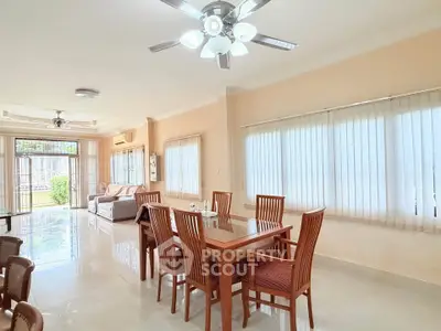 Spacious dining and living area with elegant wooden furniture and large windows.