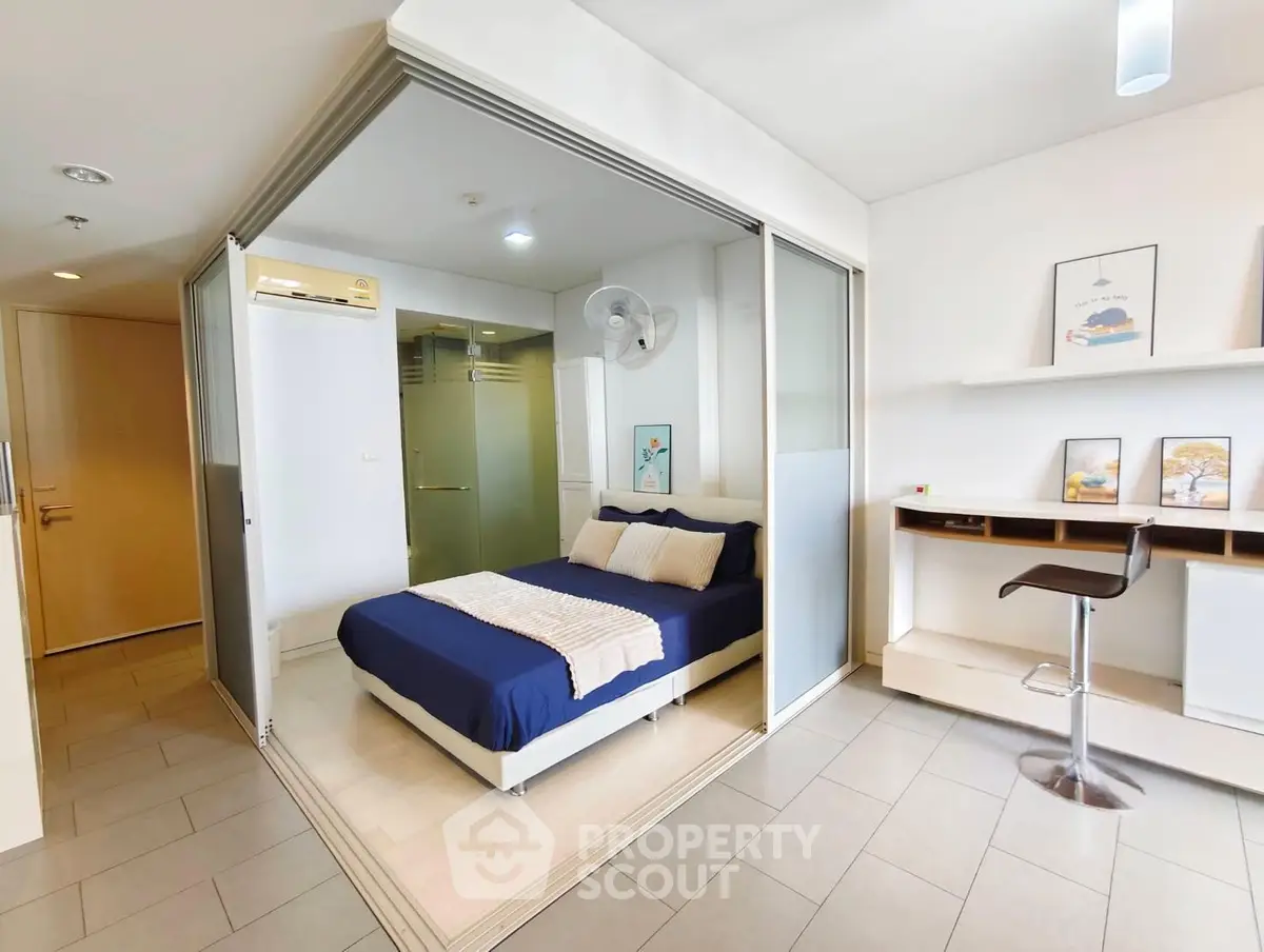 Modern studio apartment with sliding glass doors and stylish furnishings