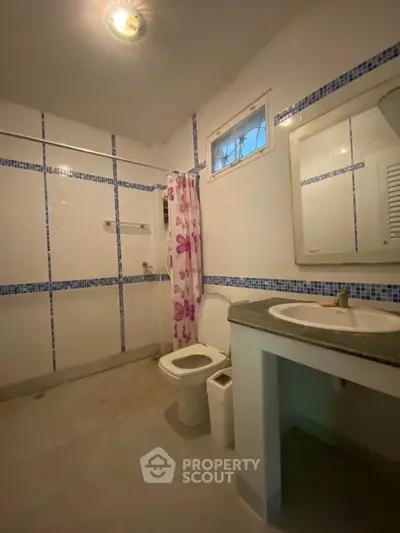 Spacious bathroom with modern fixtures and floral shower curtain
