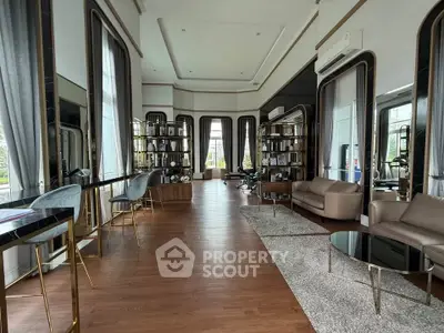 Luxurious living room with elegant decor, high ceilings, and large windows offering natural light.