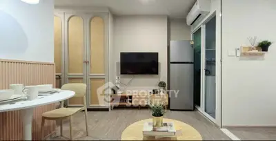 Modern living room with stylish decor and open layout, featuring a mounted TV and sleek furniture.