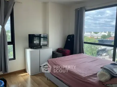 Cozy bedroom with large windows offering a scenic view, featuring a comfortable bed and modern decor.