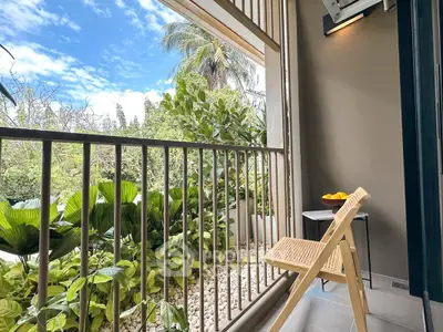 Charming balcony with lush greenery and serene outdoor view, perfect for relaxation.