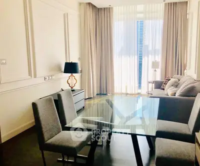 Elegant living room with glass dining table and cozy seating area, featuring floor-to-ceiling windows.