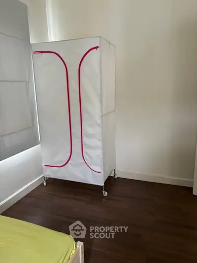 Minimalist bedroom with portable wardrobe and wooden flooring